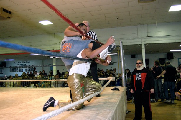 Phil E. Blunt has Chucho in the ropes as Travis Cook looks on.  (Photo Credit Mike Van Hoogstraat)