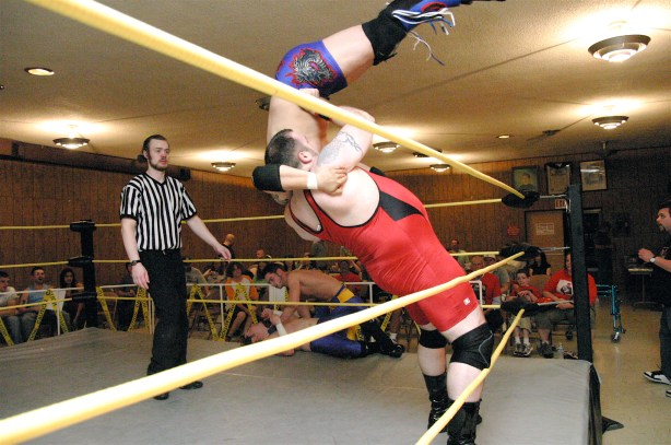 Maddog powers Ricky Kwong from the outside of the ring to the inside (Photo Credit: Mike Van Hoogstraat)