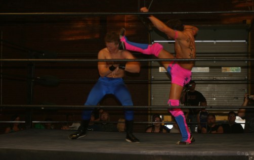 Mike Sydal gives KC Karrington a brutal boot for suggesting he have his glittery chest squeegied. [Photo credit: Angie Vo]