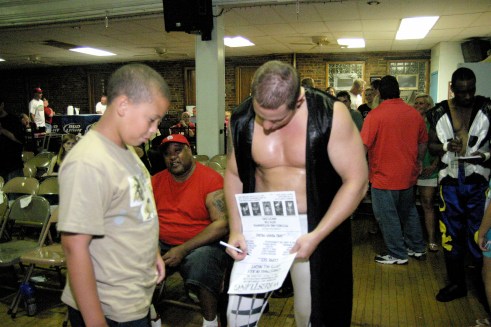 MMWA wrestlers took time to meet the fans during intermission. Blade takes time to autograph a poster for a young fan. (Photo credit: Mike Van Hoogstraat)